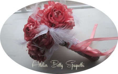 Bouquet Shabby Chic com rosas e peónias em cetim tom rosa velho, com apliques de bijuteria e plumas brancas. Pé forrado a cetim e renda branca com aplique prateado com pérola